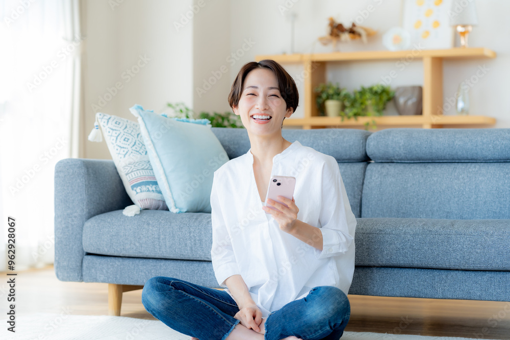 部屋でスマホを操作するミドル女性 部屋でスマホを操作するミドル女性