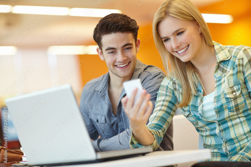 Education, laptop and phone with student friends in library on campus of college or university for development. Computer, social media and study with happy people at desk or table for research Education, laptop and phone with student friends in library on campus of college or university for development. Computer, social media and study with happy people at desk or table for research