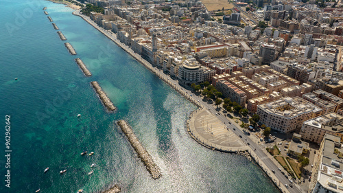 Aerial view of the seafront of Bari, Puglia, Italy. There is a road that runs along the sea and the city. The sea is clear despite the proximity of the city.