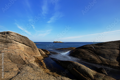 Long exposure view of wave on sea rocks agasint sea horizon of East Sea seen from Yeonggeumjeong Pavilion at Sokcho-si, South Korea photo