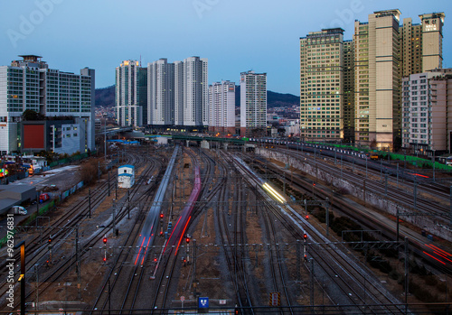 Yongsan-gu, Seoul, South Korea - January 25, 2021: High angle and night view of running subway with light trajectory against highrise apartments at Yongsan Station photo