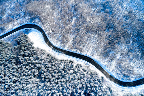 Aerial and top angle view of Snow covered curve road and trees with shaodw at Taegisan Mountain near Hoengseong-gun, South Korea photo