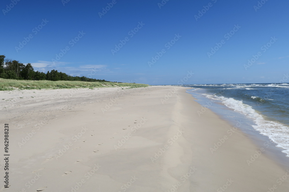 Obraz premium Am Strand Sandhammaren in Ystad lässt es sich schön spazieren. Auf der einen Seite branden die Wellen der Ostsee, auf der anderen begrenzen Dünen den Ostseestrand in der schwedischen Provinz Schonen. 