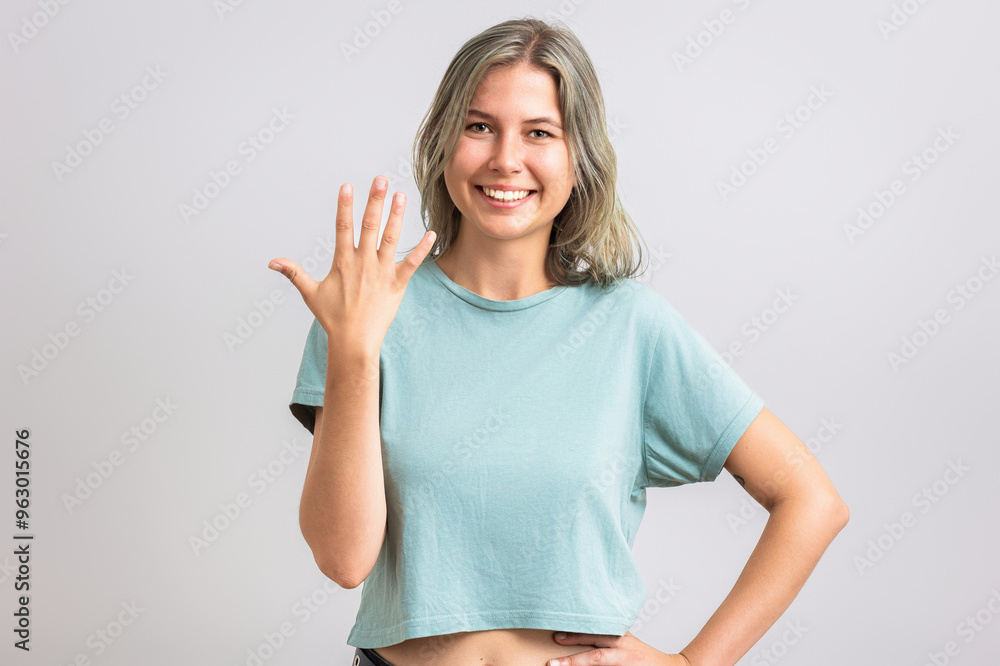 Fototapeta premium Smiling girl showing number five with her finger. Isolated on white.