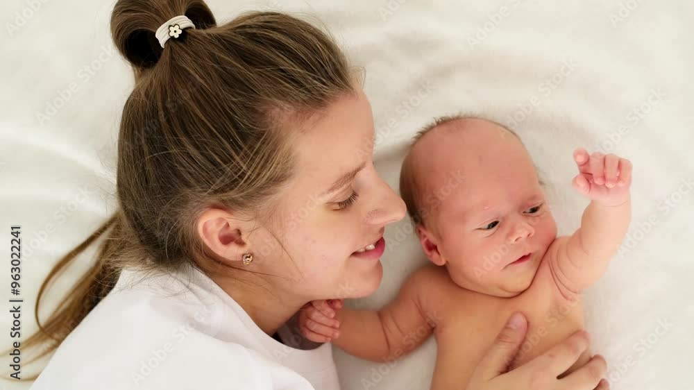 a mother with a newborn baby, a young mother gently hugs and kisses her newborn son, a space for text, a happy family and maternal love and care a mother with a newborn baby, a young mother gently hugs and kisses her newborn son, a space for text, a happy family and maternal love and care