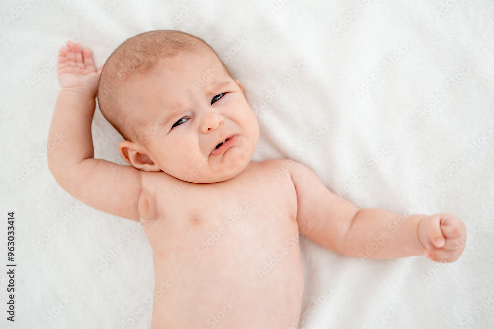crying baby, newborn baby calling for mom, crying and screaming on a white bed at home, space for text crying baby, newborn baby calling for mom, crying and screaming on a white bed at home, space for text