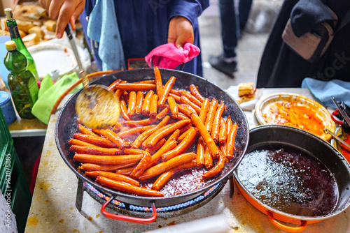 A Basque farmer (Baserritarra) roasting Txistorra (fresh chorizo) to prepare Talos, a traditional street food served during the Day of Saint Thomas. photo