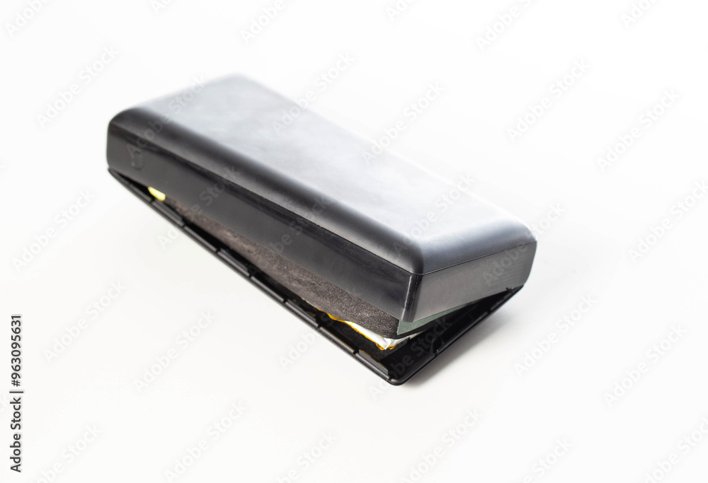 Bloated black power bank on a white background, isolate. Danger of power bank explosion, close-up Bloated black power bank on a white background, isolate. Danger of power bank explosion, close-up