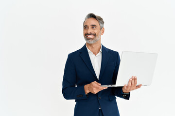 Happy mature business man using laptop standing isolated on white background. Middle aged professional businessman ceo executive wearing suit holding computer working online looking away at copy space