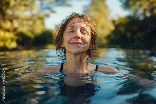 Mature woman with closed eyes is having a kneipp therapy bath in a pool