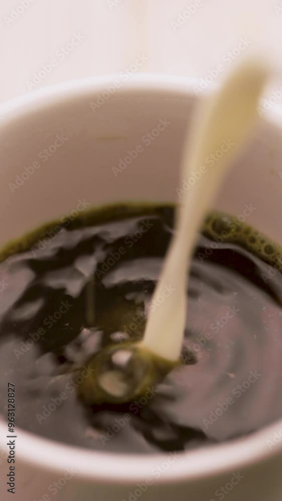 Pouring a milk in to a mug of hot coffee or tea Pouring a milk in to a mug of hot coffee or tea