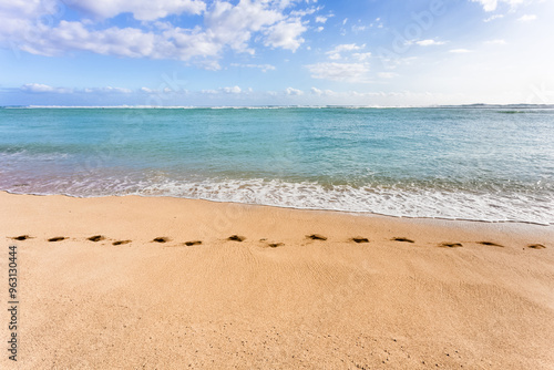 Empreintes de pieds sur le sable de plage dorée 