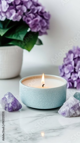 This tranquil setup features healing crystals and lilac candles on a marble table, complemented by lilac flowers, creating a perfect ambiance for meditation and spiritual rituals