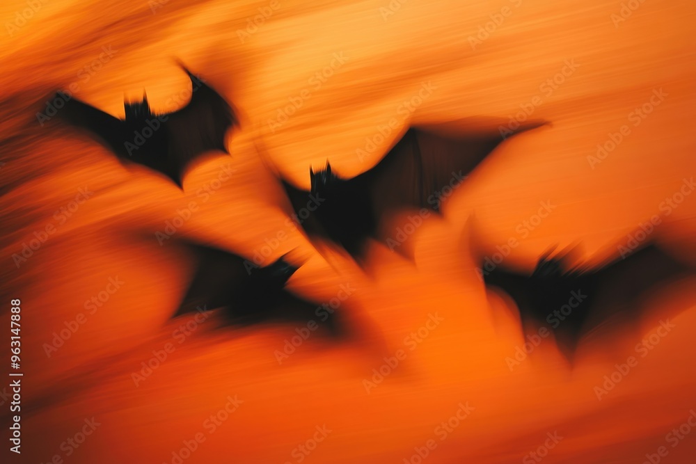 Fototapeta premium Ghostly Black Bats in Motion Against Spooky Orange Sky