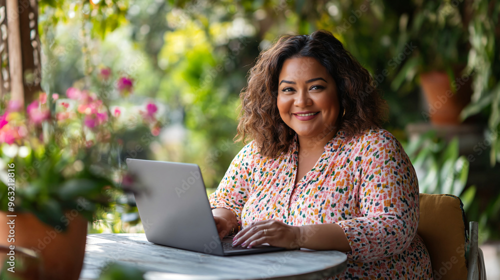 Latin female entrepreneur works remotely, happily typing on her laptop at an outdoor patio Latin female entrepreneur works remotely, happily typing on her laptop at an outdoor patio