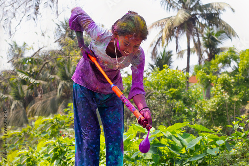 Photography girl celebrating Holi with pichkari and water colour