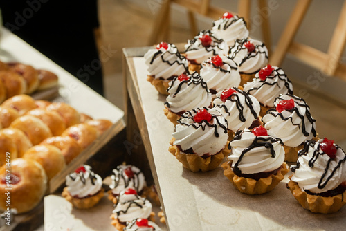 White cream cakes on a buffet table at a catering event. Food for a coffee break at a conference