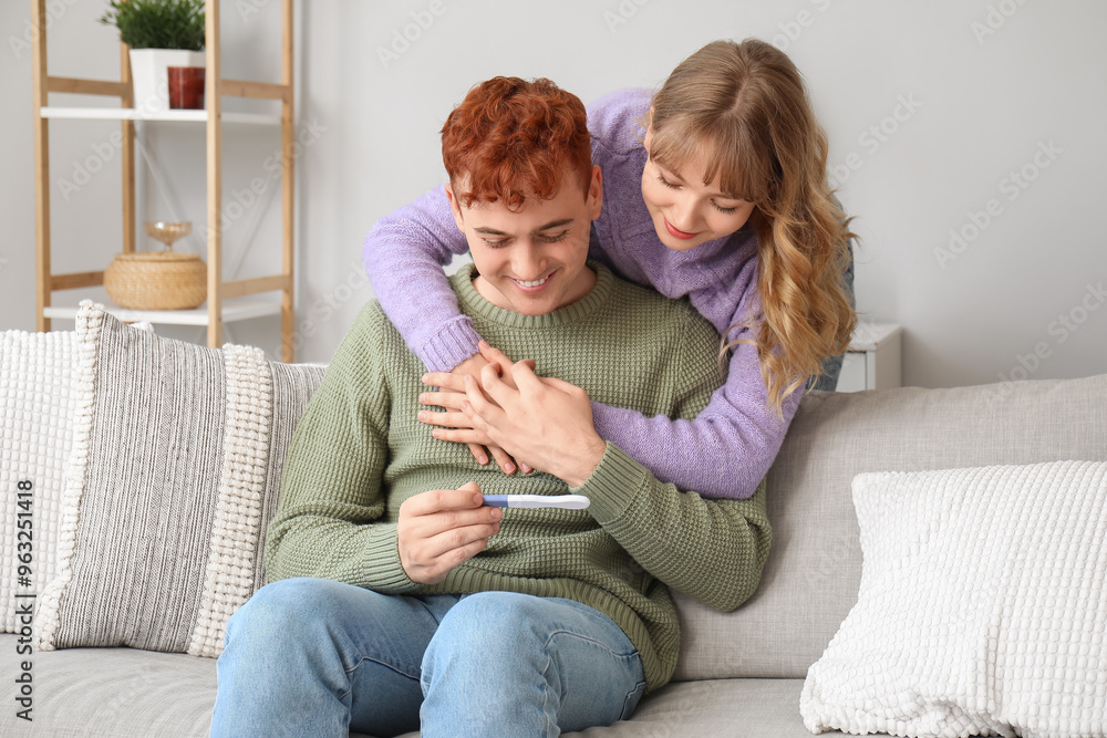 Happy young couple with pregnancy test hugging at home Happy young couple with pregnancy test hugging at home