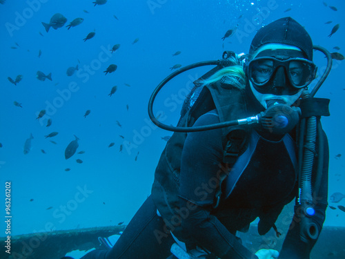 A girl with long blonde hair dive on a wreck off the Mediterranean island of Malta