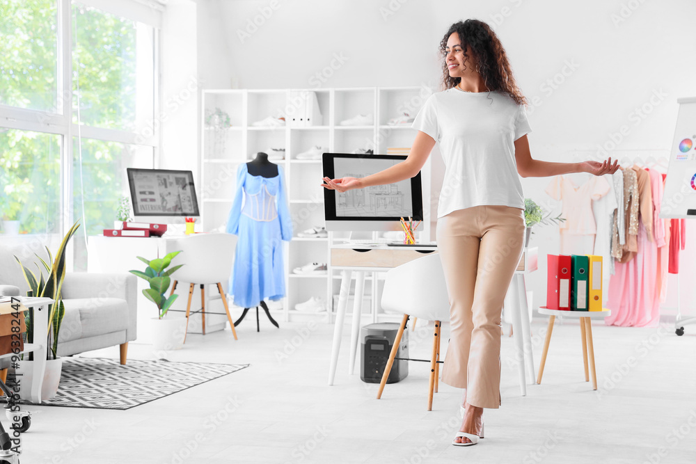Female African-American graphic designer showing something in office Female African-American graphic designer showing something in office