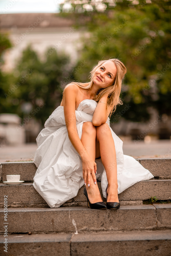 Woman city blanket. Morning in the big city. A blonde woman in a white blanket is enjoying in the city center. Photographed for social media Woman city blanket. Morning in the big city. A blonde woman in a white blanket is enjoying in the city center. Photographed for social media