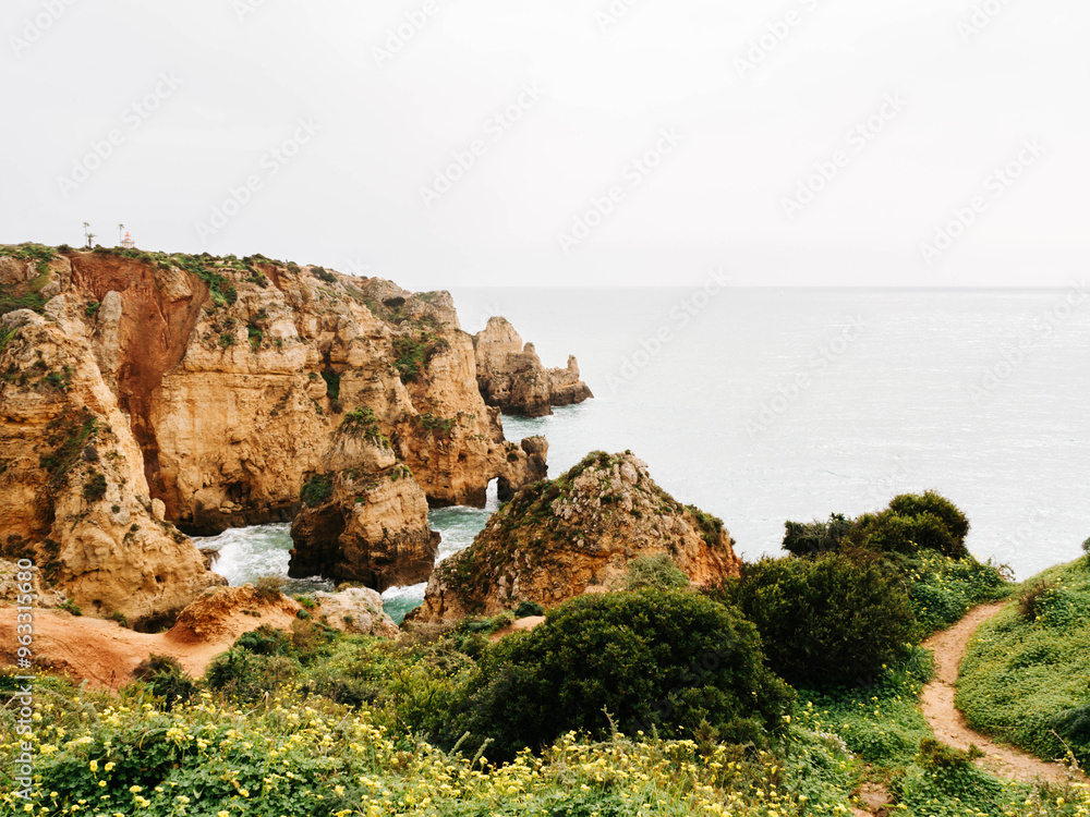 Scenic coastal cliffs covered in greenery, with dramatic rock formations jutting into the calm ocean Scenic coastal cliffs covered in greenery, with dramatic rock formations jutting into the calm ocean