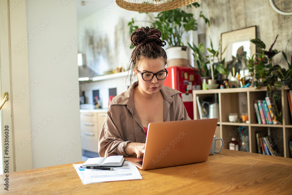 Young hipster woman working on laptop from home Young hipster woman working on laptop from home