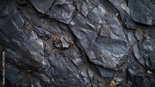 Close-up of a dark stone texture, emphasizing its gritty surface and small, scattered mineral deposits