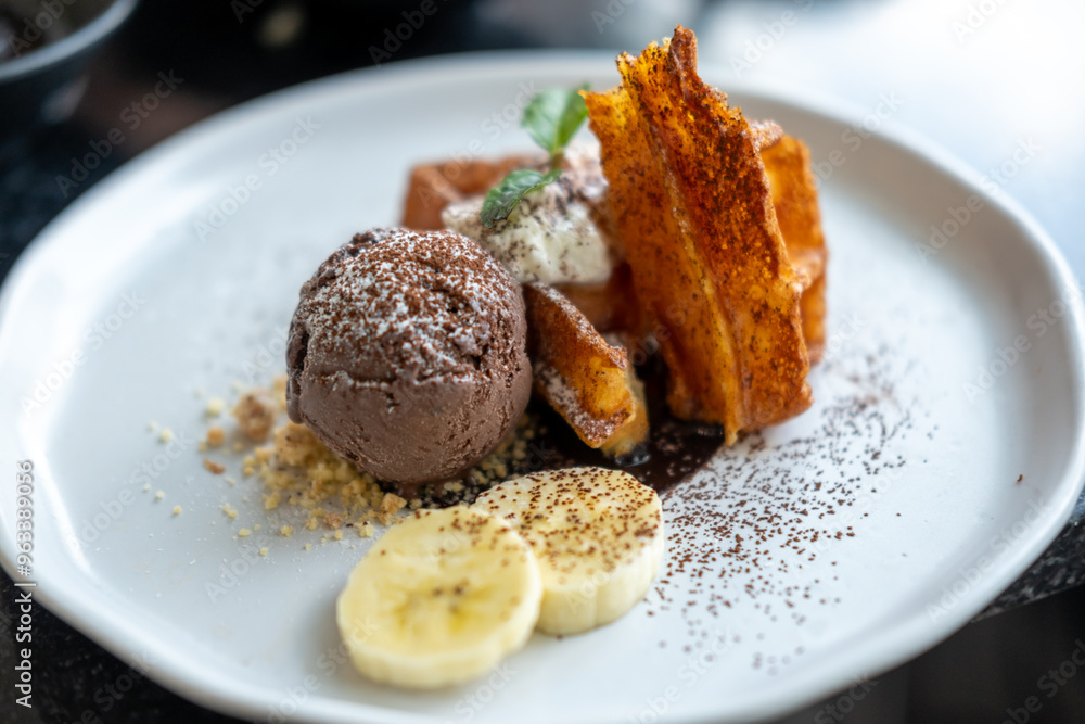 Waffle with chocolate ice cream served with cookie crumble, whipped cream and banana on plate Waffle with chocolate ice cream served with cookie crumble, whipped cream and banana on plate