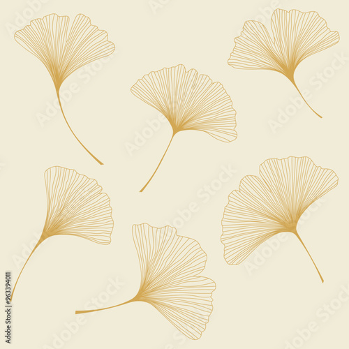 Set of gold ginkgo biloba leaves on light beige background.