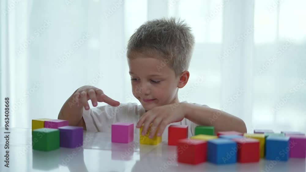 Focused child play with colorful block. Kindergarten learning through play. Child building with toy blocks. Early education concept. childhood creativity. Preschool child enjoying toys at kindergarten Focused child play with colorful block. Kindergarten learning through play. Child building with toy blocks. Early education concept. childhood creativity. Preschool child enjoying toys at kindergarten