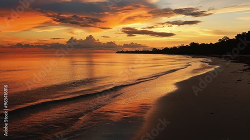 A tranquil beach at sunset, with the sky ablaze in warm colors and the sea reflecting the golden light, capturing the calm of evening