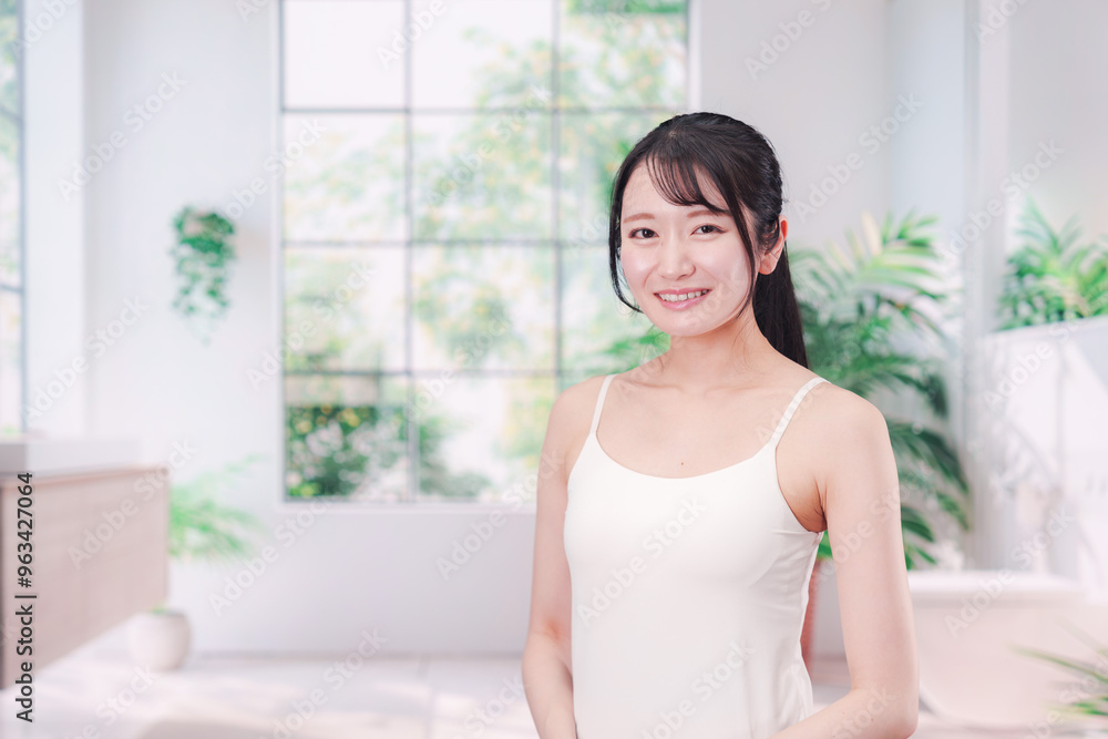 笑顔でビューティーケアをする若い女性 笑顔でビューティーケアをする若い女性