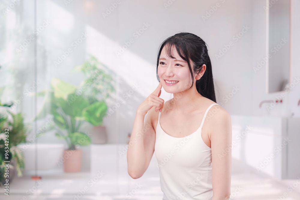 笑顔でビューティーケアをする若い女性 笑顔でビューティーケアをする若い女性