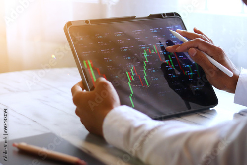 Businessman analyzing stock market on tablet