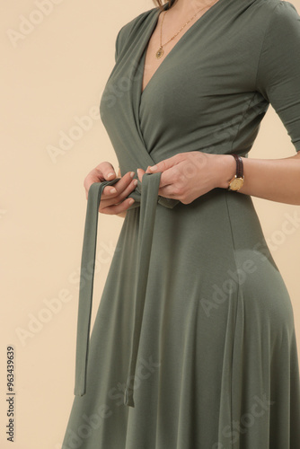 Serie of studio photos of young female model in green viscose wrap dress. photo