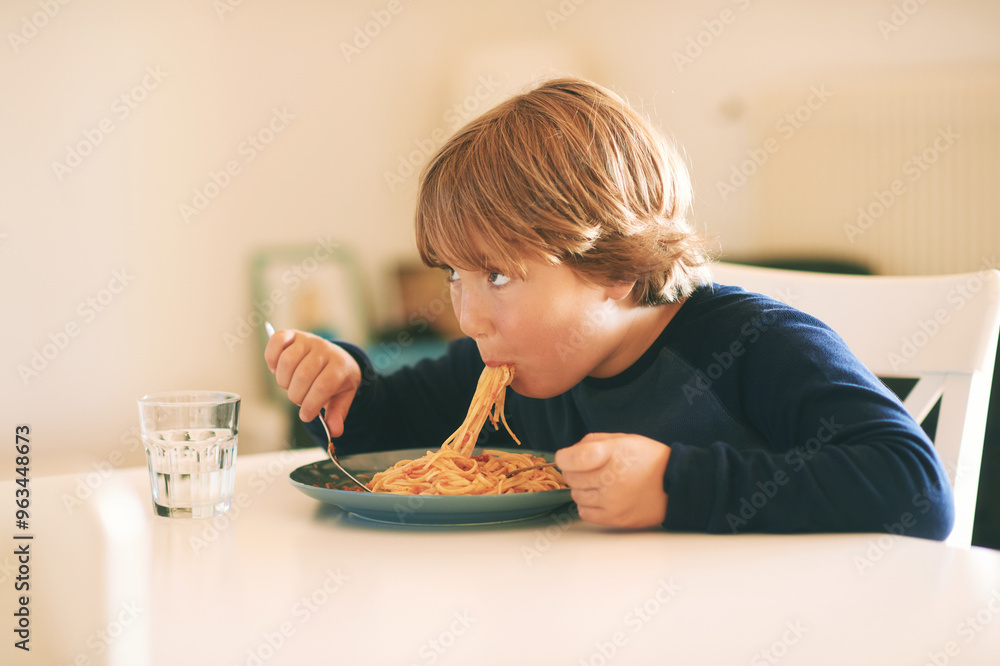 Home portrait of cute little boy eating pasta with tomato sauce Home portrait of cute little boy eating pasta with tomato sauce