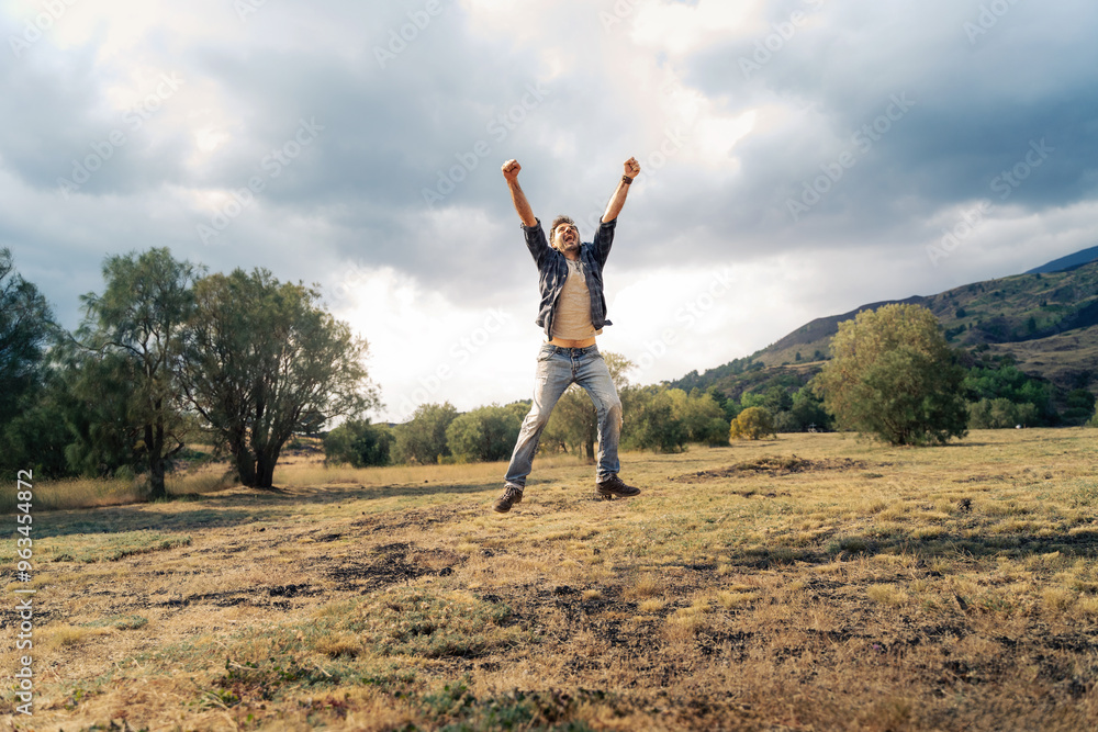Man leaping with triumph in majestic natural setting Man leaping with triumph in majestic natural setting