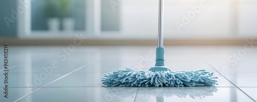 Close-up of a mop head moving in circular motions on a white tile floor, leaving streak-free results, mop on tile floor, polished cleaning photo