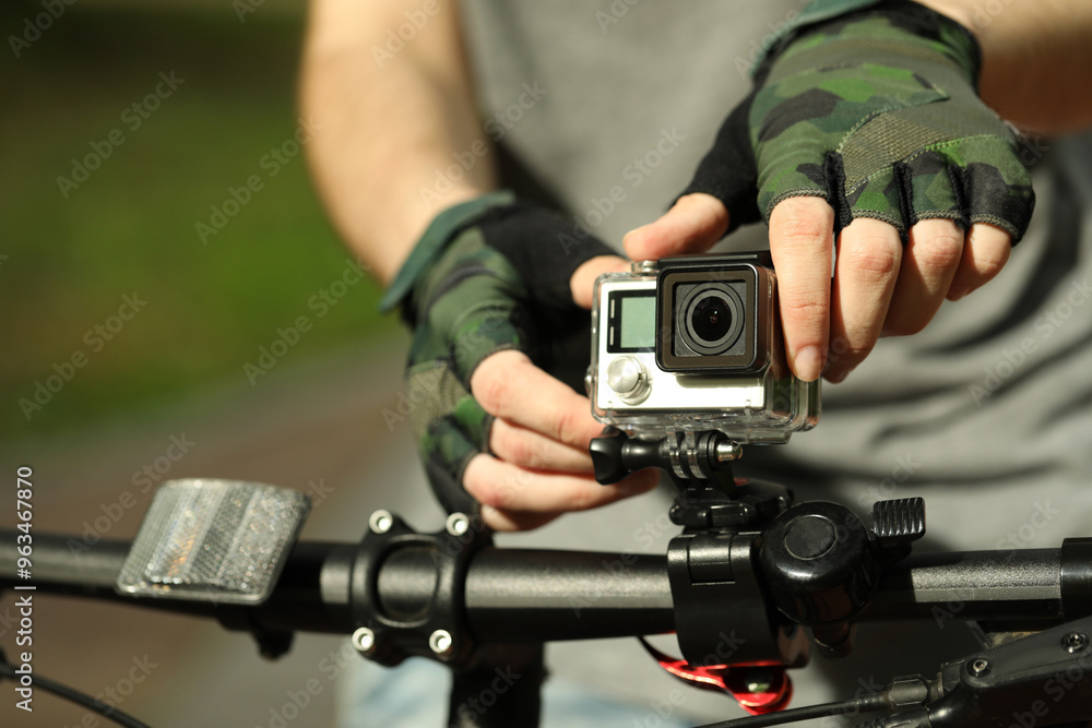 Obraz premium Man with modern action camera on bicycle outdoors, closeup