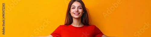 Photo of an optimistic brunette holding like empty space wearing a red shirt isolated on an orange background.  photo