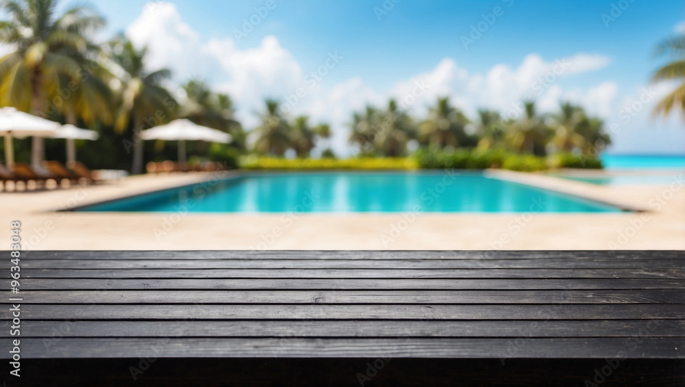 Obraz premium The empty black wooden table top with blur background of swimming pool on the beach. For product display