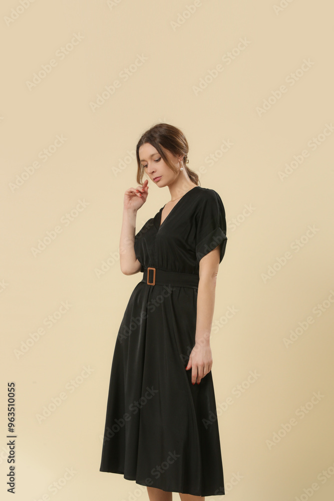 Fototapeta premium Serie of studio photos of young female model in soft cotton black midi dress. 