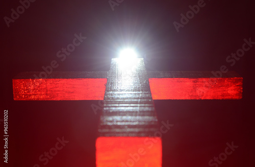 Christian wooden cross with light at the end of the cross