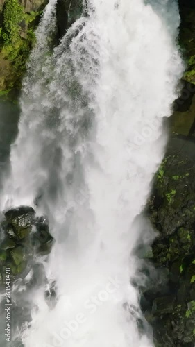 Aerial view of water stream with splash and mist. Limunsudan Falls. Mindanao, Philippines. Slow motion. Vertical view. photo