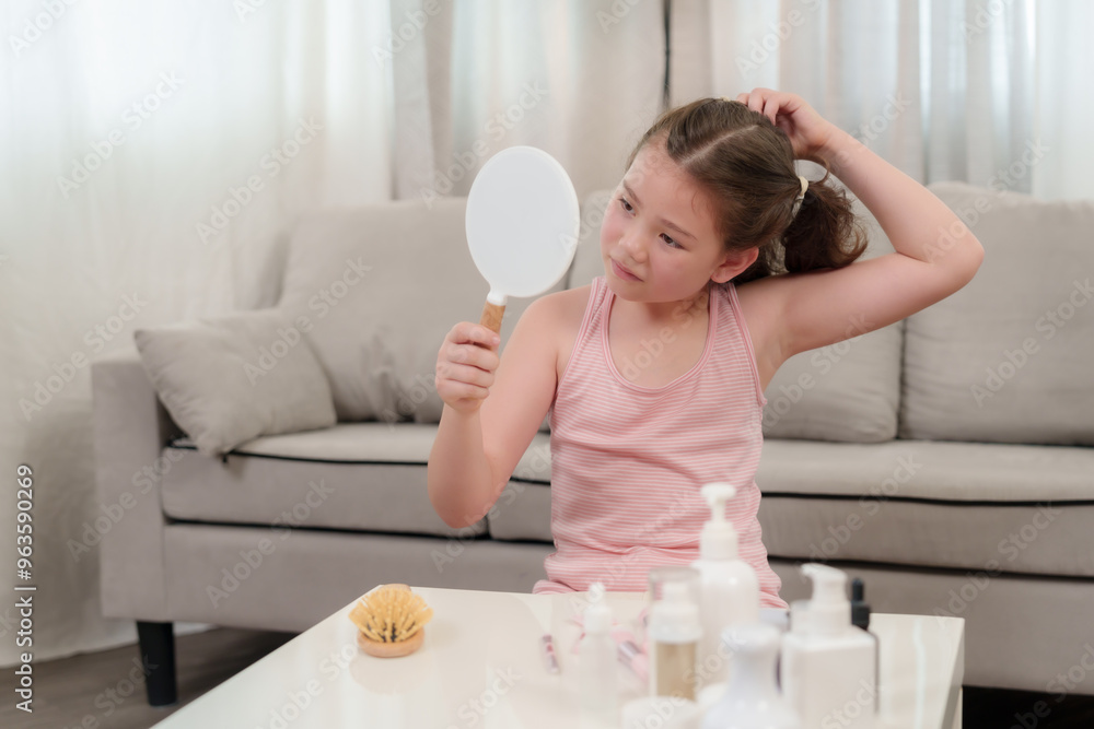 Young half-Asian girl holding hairbrush with playful expression, brushing hair in front of mirror. Surrounded by beauty products and tools. Expressing joy and self-care during beauty routine at home. Young half-Asian girl holding hairbrush with playful expression, brushing hair in front of mirror. Surrounded by beauty products and tools. Expressing joy and self-care during beauty routine at home.