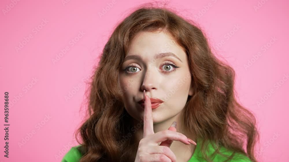 Beautiful woman holding finger on lips, pink studio background. Pretty lady with gesture of shh, secret, silence, conspiracy, gossip, rumors concept. Beautiful woman holding finger on lips, pink studio background. Pretty lady with gesture of shh, secret, silence, conspiracy, gossip, rumors concept.