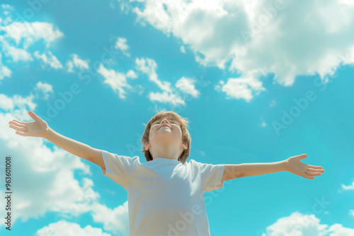 relaxed boy breathing fresh air raising arms over blue sky