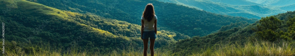 Young girl gazes at breathtaking green mountain landscape at sunset Young girl gazes at breathtaking green mountain landscape at sunset