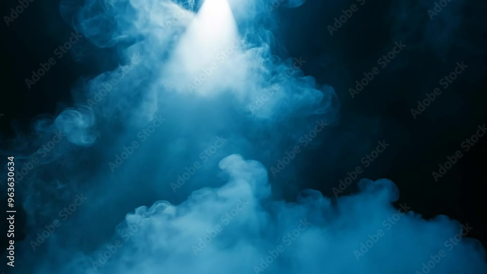 Blue smoke on a black background illuminated by a bright spotlight Blue smoke on a black background illuminated by a bright spotlight
